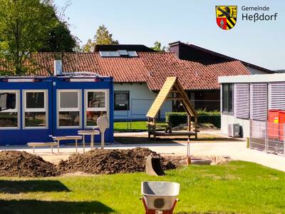 Im Hintergrund gut zu erkennen ist das Bestandsgebäude der Kita, das ab Herbst umfassend saniert und erweitert wird. Durch den Baustellenbetrieb sind die Kinder auch vom dortigen Garten abgeschnitten, weshalb die Spielgeräte nun zur Containeranlage versetzt wurden.