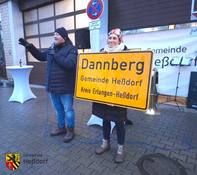 Erster Bürgermeister Axel Gotthardt und Zweite Bürgermeisterin Anja Willert versteigern die falsch gedruckten Heßdorfer Ortsschilder zugunsten der Jugendfeuerwehr.